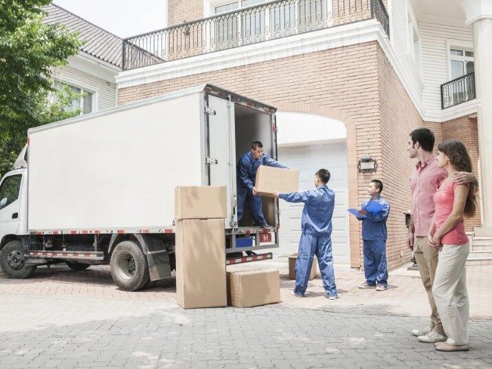 movers carrying heavy boxes down a flight of stairs in Porter Ranch